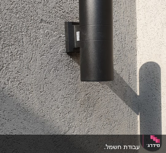 מנורת קיר שחורה מותקנת על קיר בטון